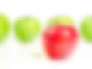 roter Apfel vor grünen Äpfeln