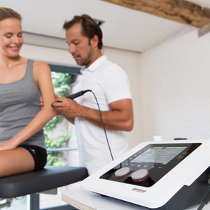 Physiotherapie mit Kombinationsgerät Gymna Combi 200 Therapeut behandelt sitzende Patientin am Rücken