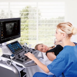 Untersuchung mit Ultraschallgerät VINNO G50 Ärztin sitzt beim Ultraschallgerät und untersucht Mann liegend